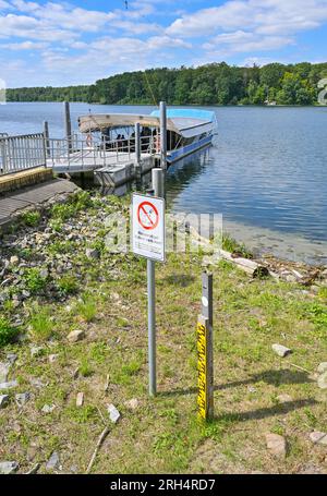 Strausberg, Deutschland. 11. Aug. 2023. Eine Wasserstandsanzeige am Straussee ist seit langem trocken. Der See hat etwa zehn Jahre lang die Hälfte seines Wassers verloren. Seit 2014 ist der Wasserstand jedes Jahr um etwa 20 Zentimeter gesunken. Die Ursache für den Wasserverlust ist nicht bekannt. Zu diesem Thema wurde ein Sachverständigengutachten in Auftrag gegeben. Kredit: Patrick Pleul/dpa/Alamy Live News Stockfoto