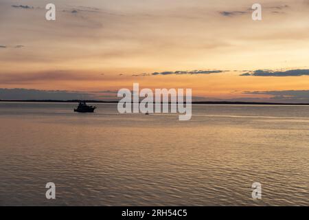 Fraser Island K'gari Sonnenuntergang über Kingfisher Bay und dem Korallenmeer mit Boot Silhouette, Queensland, Australien Stockfoto