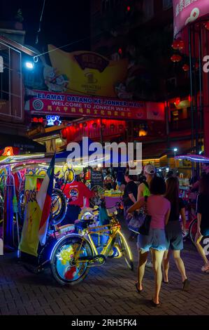 Trishaws warten auf Geschäfte am Eingang zum Jonker Walk Night Market, Malacca, Malaysia Stockfoto