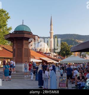 Touristen rund um das Sebilj, ein Founatin im ottomanischen Stil im Stadtteil Baščaršija in Sarajevo, Bosnien und Herzegowina, 13. August 2023. Stockfoto