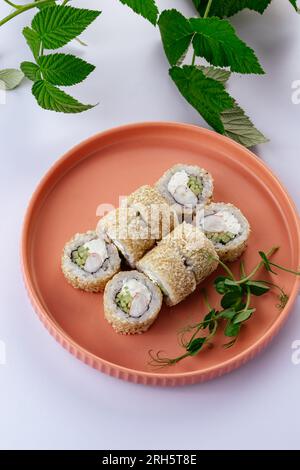 japanische Sushi-Brötchen in weißem Sesam auf einem Teller. Stockfoto