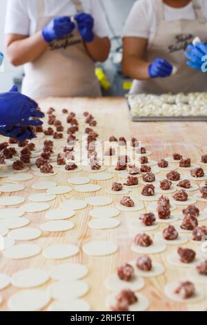 Mehrere weibliche Köche bereiten Knödel in der Küche zu Stockfoto