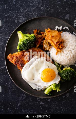 Koreanisches Brathähnchen mit Kimchi, Brokkoli und Ei Stockfoto