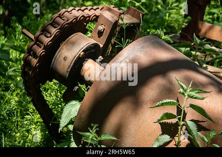 Rostige Antriebszahnräder mit Metallkette an einem alten Bergwerkswaggon zum Absaugen von Holzkohle aus dem Minenfeld, Dampfantriebsmotor außer Betrieb Stockfoto