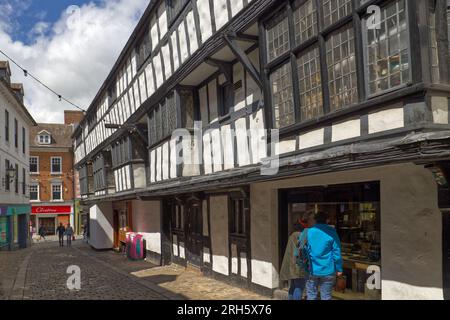 Shrewsbury, Shropshire, England, Großbritannien - Leute, die in einem Schaufenster im historischen mittelalterlichen Fachwerkgebäude des Abbots House in der Butcher Row suchen Stockfoto