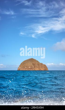 Vulkanische Insel in der Wüste vom Wasser aus gesehen, Galapagos-Nationalpark, Ecuador. Stockfoto