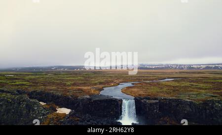 Majestätisches Panorama der Oxarafoss-Kaskade, Luftblick auf den isländischen Wasserfall, der den Berg hinunterläuft. Ein riesiger Fluss fließt und fällt von großen Felsen in island. Zeitlupe. Stockfoto