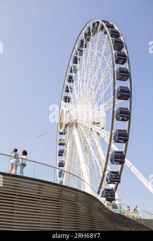 Navy Pier Centennial Rad von unten mit zwei Touristen warten in einer Seite mit einem Teleobjektiv, Chicago, Illinois, USA Stockfoto