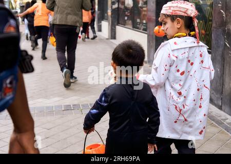 Verschiedene Kinder gehen die Straße entlang in halloween-Kostümen Stockfoto