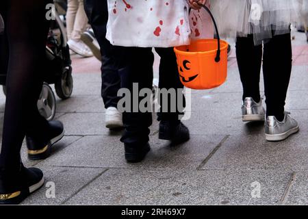 Kinder in Gewohnheiten, die an halloween auf der Straße spazieren Stockfoto