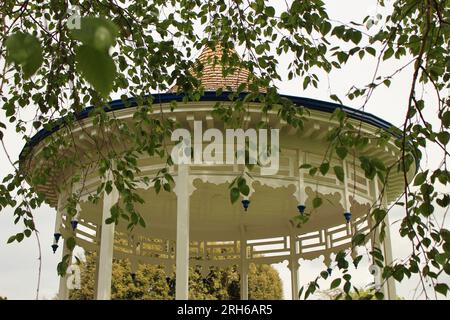 Pittville Park Bandstand. Top of the restored Regency bandstand next to the Pittville Pump Rooms, Cheltenham Spa, Gloucestershire with leaves in front Stock Photo