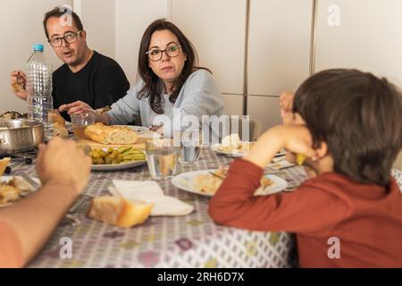 Ein Paar mit Kind isst mit der Familie zu Mittag Stockfoto