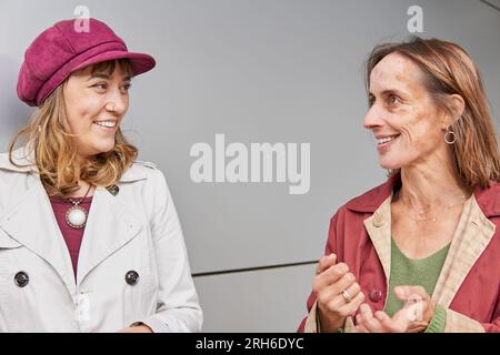 Glückliche Frau mit Vitiligo, die mit einem Freund aus einer anderen Generation spricht Stockfoto