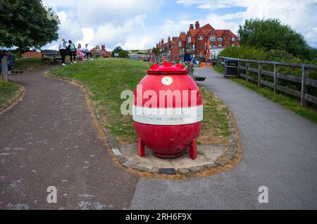 Rot-weiß bemalte Seemine als Sammelbox in Robin Hood's Bay Stockfoto