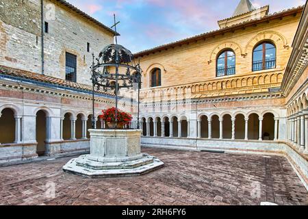 Foligno, Umbrien, Italien. Abbey of Santa Croce (1070 in Sassovivo). Romanischer Kreuzgang (1229) mit viereckigem Grundriss und einem Brunnen in der Mitte. Stockfoto