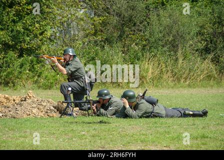 Reenactors, Reenactment deutscher Soldaten des Zweiten Weltkriegs. Wehrmachts-Infanteristen in Uniform. MG 34 Maschinengewehr-Kampfszenario Stockfoto