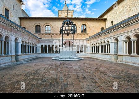 Foligno, Umbrien, Italien. Abbey of Santa Croce (1070 in Sassovivo). Romanischer Kreuzgang (1229) mit viereckigem Grundriss und einem Brunnen in der Mitte. Stockfoto