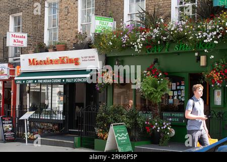 Euston, London, Großbritannien. 10. August 2023. Indische und südostasiatische Restaurants in der Drummond Street auf der Rückseite der Euston Station. Kürzlich wurde berichtet, dass die Anzahl der beliebten Restaurants in der Drummond Street gesunken ist, nicht nur seit der Covid-19-Pandemie, sondern seit Beginn der Bauarbeiten für die Hochgeschwindigkeitsbahn HS2. Einige der Straßen in der Gegend sind wegen HS2 Bauarbeiten gesperrt, so dass es weniger Parkplätze für Gäste gibt. Das Hochgeschwindigkeitsbahnprojekt HS2 in Euston in London wurde vor kurzem für zwei Jahre auf Eis gelegt, aber auf der HS2 laufen noch Arbeiten Stockfoto