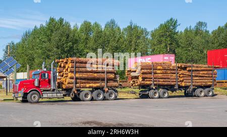 LKW und Anhänger beladen mit Holzscheiten auf einem Parkplatz in Houston, British Columbia. British Columbia ist einer der weltweit größten Exporteure von Holz p Stockfoto