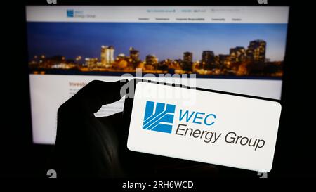 Person, die ein Smartphone mit dem Logo des US-Versorgungsunternehmens WEC Energy Group Inc. Auf dem Bildschirm vor der Website hält. Konzentrieren Sie sich auf das Display des Telefons. Stockfoto