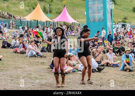 Winchester, Großbritannien. 13. Aug. 2023. Besucher, die Livemusik beim Boomtown Fair Festival genießen. Boomtown alias Boomtown Fair ist ein britisches Musikfestival, das jährlich im South Downs National Park in der Nähe von Winchester, Hampshire, stattfindet. Seit 2009 bietet Boomtown ein vielfältiges Angebot an Bands, DJs und Rednern auf vielen verschiedenen Bühnen an. Jedes jährliche Event wird als „ein Kapitel“ bezeichnet und erweitert die Story des Vorjahres, erzählt durch die Sets und Live-Schauspieler, die durch die Stätte schlendern. Kredit: SOPA Images Limited/Alamy Live News Stockfoto