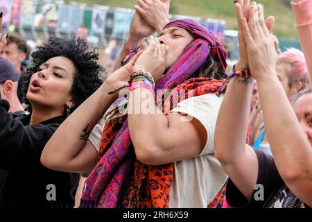 Winchester, Großbritannien. 13. Aug. 2023. Besucher, die Livemusik beim Boomtown Fair Festival genießen. Boomtown alias Boomtown Fair ist ein britisches Musikfestival, das jährlich im South Downs National Park in der Nähe von Winchester, Hampshire, stattfindet. Seit 2009 bietet Boomtown ein vielfältiges Angebot an Bands, DJs und Rednern auf vielen verschiedenen Bühnen an. Jedes jährliche Event wird als „ein Kapitel“ bezeichnet und erweitert die Story des Vorjahres, erzählt durch die Sets und Live-Schauspieler, die durch die Stätte schlendern. Kredit: SOPA Images Limited/Alamy Live News Stockfoto