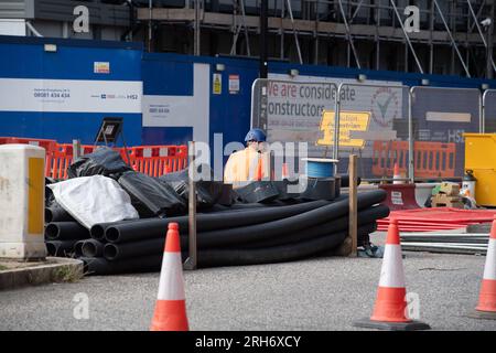 Camden, London, Großbritannien. 10. August 2023. HS2 Hochgeschwindigkeitsarbeiten auf einer Straße außerhalb eines HS2-Komplexes im Nordwesten Londons in Camden, in der Nähe der Euston Station. Die Arbeiten am Hochgeschwindigkeitsbahnprojekt HS2 in Euston in London wurden zwei Jahre lang ausgesetzt. Die beiden Tunnelbohrmaschinen für den Euston-Teil des Projekts sollen nächstes Jahr in der Old Oak Common Station unterirdisch vergraben werden, die dann wieder einsatzbereit ist, falls der zentrale Londoner Teil des viel kritisierten HS2-Projekts wieder grünes Licht erhält. HS2 liegt mit den aktuellen Kostenschätzungen für den Bau des Euston deutlich über dem Budget Stockfoto