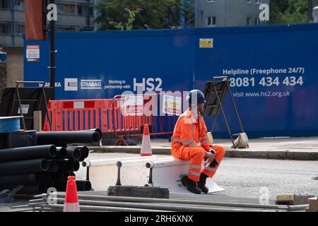 Camden, London, Großbritannien. 10. August 2023. HS2 Hochgeschwindigkeitsarbeiten auf einer Straße außerhalb eines HS2-Komplexes im Nordwesten Londons in Camden, in der Nähe der Euston Station. Die Arbeiten am Hochgeschwindigkeitsbahnprojekt HS2 in Euston in London wurden zwei Jahre lang ausgesetzt. Die beiden Tunnelbohrmaschinen für den Euston-Teil des Projekts sollen nächstes Jahr in der Old Oak Common Station unterirdisch vergraben werden, die dann wieder einsatzbereit ist, falls der zentrale Londoner Teil des viel kritisierten HS2-Projekts wieder grünes Licht erhält. HS2 liegt mit den aktuellen Kostenschätzungen für den Bau des Euston deutlich über dem Budget Stockfoto