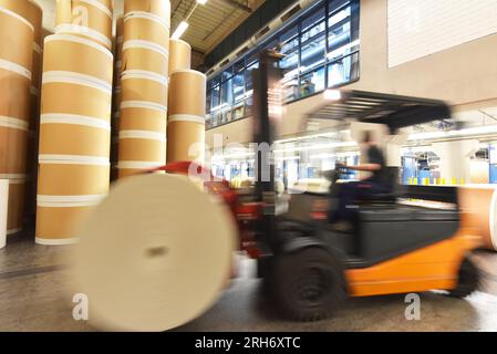 Lagerung von Papierrollen in einer großen Druckerei - Transport mit einem Gabelstapler Stockfoto