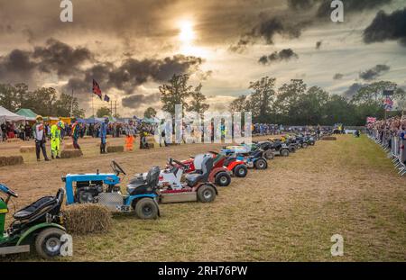 Die Fahrer stellen sich gegenüber ihren Rasenmähern auf und sind bereit für den Start des alljährlichen Tag/Nacht-Rennens der British Lawn Mower Racing Association endu im Le Mans-Stil Stockfoto