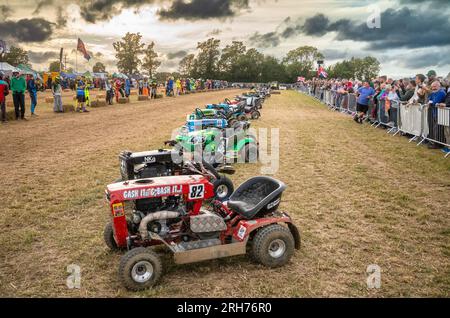 Die Fahrer stellen sich gegenüber ihren Rasenmähern auf und sind bereit für den Le Mans Style Start des jährlichen BLMR der British Lawn Mower Racing Association Stockfoto