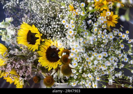 Gelbe Sonnenblumen, weiße Gänseblümchen und Gänseblümchen in einem Blumenstrauß für Geburtstage und besondere Anlässe Stockfoto