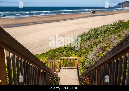 Holzsteg, Treppe zum Pazifischen Ozean am Cannon Beach, Oregon. Eine Holztreppe mit Geländern führt zum Meer, das zum Strand führt Stockfoto