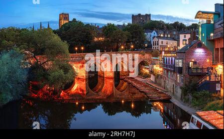 Ein Blick in die Dämmerung im Sommer in Durham City mit Blick auf die beleuchtete Elvet Bridge in Richtung Durham Castle und Durham Cathedral mit River Wear Stockfoto