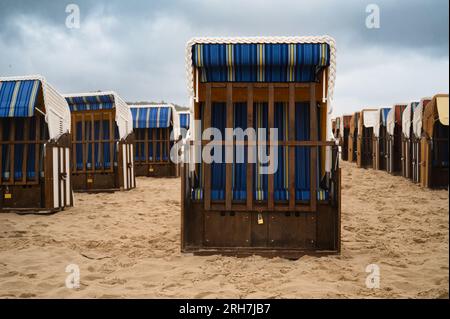 Überdachte Rattan-Liegestühle am ostseestrand, Küste auf der Insel Usedom in Deutschland, Sturm und Regen über dem Brackwasser, hohe Wellen, Stor Stockfoto