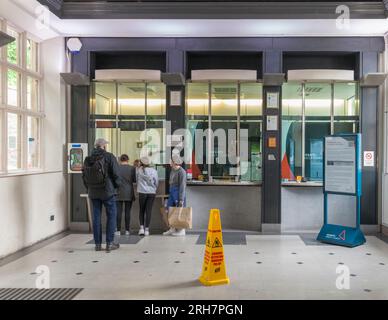 Warteschlange am Ticketschalter des Bahnhofs Lancaster mit einem Fahrgast, der ein Ticket kauft Stockfoto