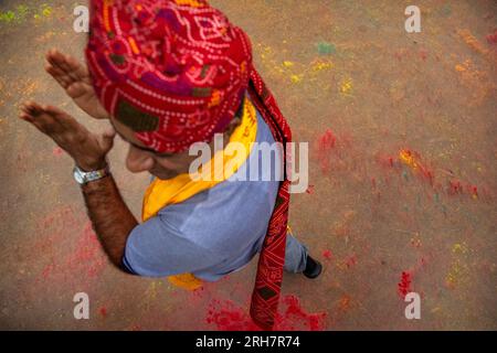 Während des Indian Holi Festival of Colors spaziert ein Indianer in einem bunten, leuchtenden Turban durch ein Feld Stockfoto