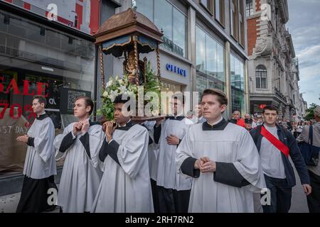 London, Großbritannien. 13. August 2023. Feier der Himmelfahrt der Gemeinde All Saints Margaret Street, die die Oxford Street hinuntermarschiert. Der heilige Tag der Himmelfahrt ist der Anlass für den körperlichen Aufstieg der Jungfrau Maria in den Himmel am Ende ihres Lebens. Kredit: Guy Corbishley/Alamy Live News Stockfoto