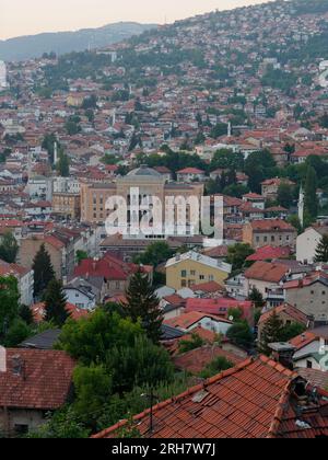 Erhöhter Blick über die Stadt Sarajevo an einem Sommerabend mit Rathauzentrum, Bosnien und Herzegowina, August 14,2023 Stockfoto