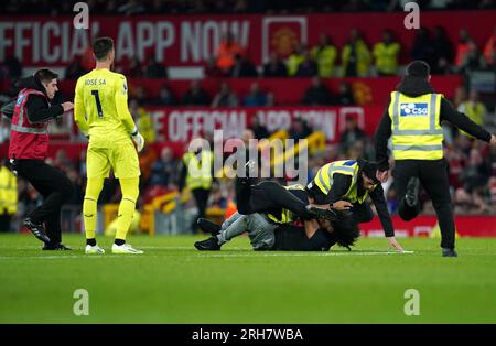 Der Torwart der Wolverhampton Wanderers Jose Sa, der während des Premier League-Spiels in Old Trafford, Manchester, auf dem Spielfeld vor Ort angreift, wird von der Sicherheitsabteilung angegriffen. Foto: Montag, 14. August 2023. Stockfoto