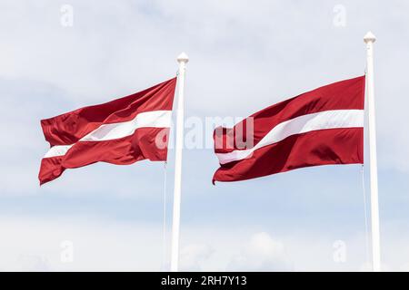 Zwei lettische Flaggen winken im Wind. Stockfoto