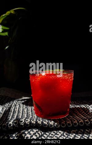 Erfrischende Wassermelone agua Fresca mit jalapeño und Wassermelonen-Eisbällen auf schwarz-weißem Tuch in der Sonne Stockfoto