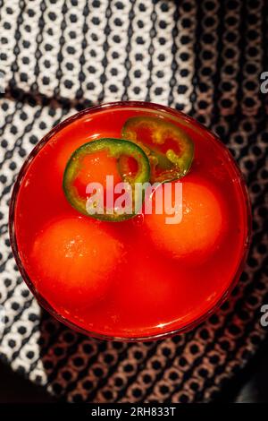 Erfrischende Wassermelone agua Fresca mit jalapeño und Wassermelonen-Eisbällen auf schwarz-weißem Tuch in der Sonne Stockfoto