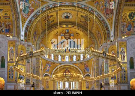 Die kunstvoll verzierte Decke mit goldenen Fresken und Radleuchtern an der Kirche St. Sava (1935-2004) in Belgrad, Serbien Stockfoto