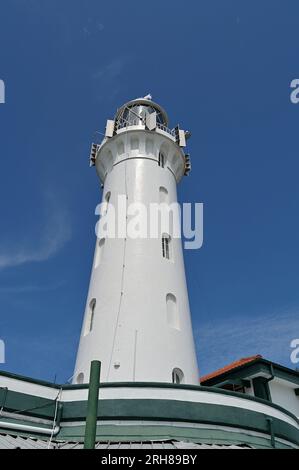 Der zylindrische weiße Turm des Raffles Lighthouse befindet sich auf Pulau Satumu, der südlichsten Insel vor dem Festland in der Straße von Singapur. Stockfoto