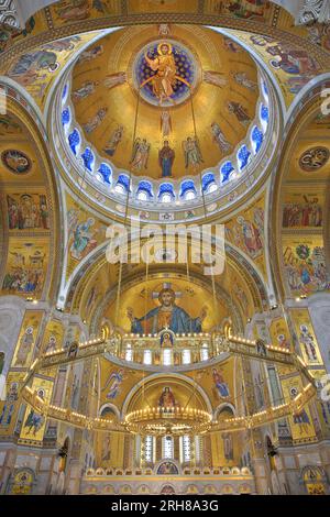 Die kunstvoll verzierte Decke mit goldenen Fresken und Radleuchtern an der Kirche St. Sava (1935-2004) in Belgrad, Serbien Stockfoto