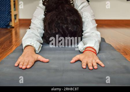 Eine Frau, die im Haus Yoga praktiziert. Heilpraktiken. Stockfoto