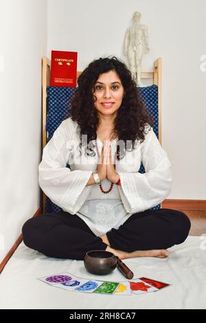 Eine Frau, die Meditation und Heilung mit einer tibetischen Gesangsschale praktiziert. Stockfoto