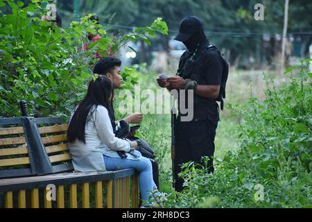 14. August 2023, Srinagar, Jammu und Kaschmir, Indien: Ein indischer Polizist prüft den Personalausweis von Einheimischen in einem Park vor Indiens Unabhängigkeitstag am 14. August 2023 in Srinagar, indischer Administration in Kaschmir, Indien. Im Vorfeld der Feierlichkeiten zum Indischen Unabhängigkeitstag wurden in Kaschmir unter indischer Verwaltung verstärkte Sicherheitsmaßnahmen ergriffen. Weitere Kräfte der indischen Regierung haben strategisch platzierte Barrikaden für die Zufallsdurchsuchung von Fahrzeugen und Fußgängern in der Region eingesetzt. (Kreditbild: © Mubashir Hassan/Pacific Press via ZUMA Press Wire) NUR REDAKTIONELLE VERWENDUNG! Nicht für kommerzielle USAG Stockfoto