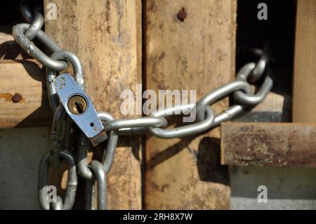 Kettenschloss an einem Zaun aus Bambus Stockfoto